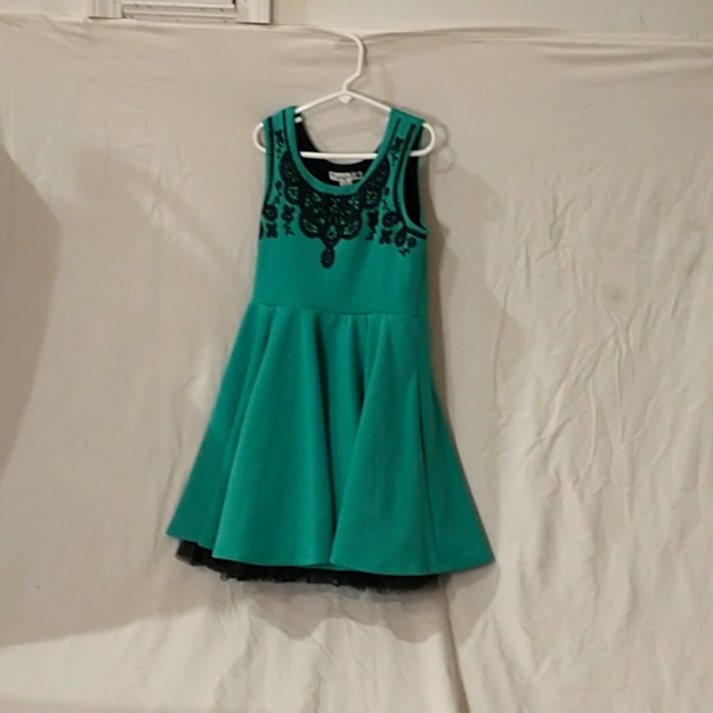 A knit works dress and it is a size 12 in kids and it is the color teal green.
